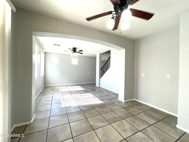 tiled spare room featuring ceiling fan