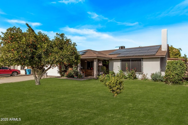 view of front of house featuring a garage, a front yard, and solar panels