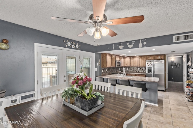 6408 W College Dr, Phoenix, AZ 85033 - dining room featuring light tile patterned flooring, sink, a textured ceiling, and french doors