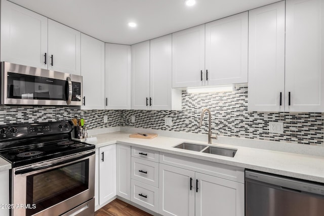 kitchen featuring appliances with stainless steel finishes, white cabinets, and a sink