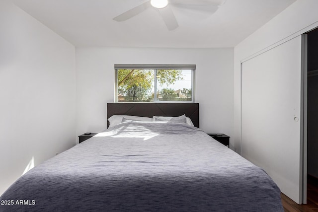 bedroom with dark wood-style floors, a closet, and a ceiling fan