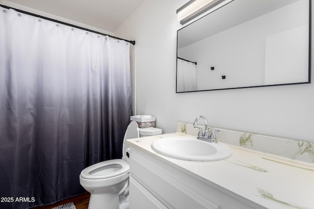 bathroom featuring toilet, a shower with shower curtain, and vanity