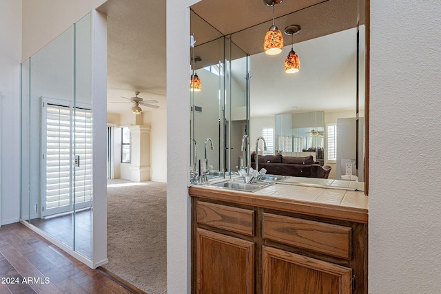 bathroom with ceiling fan, hardwood / wood-style floors, vanity, and a textured ceiling