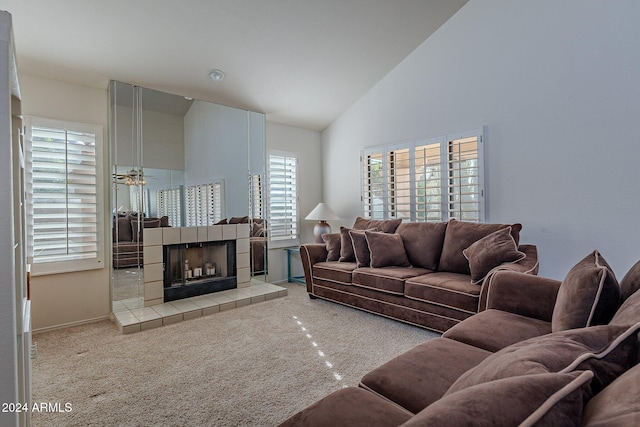 living room with a tiled fireplace, light carpet, ceiling fan, and high vaulted ceiling