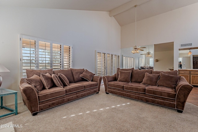 carpeted living room with beamed ceiling, high vaulted ceiling, and ceiling fan