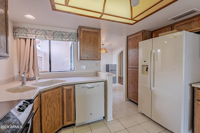 kitchen featuring sink, light tile patterned flooring, and white appliances