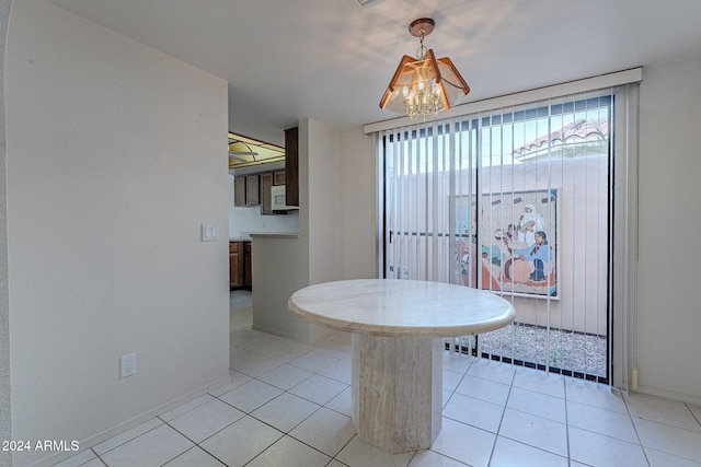 unfurnished dining area featuring light tile patterned floors and a notable chandelier