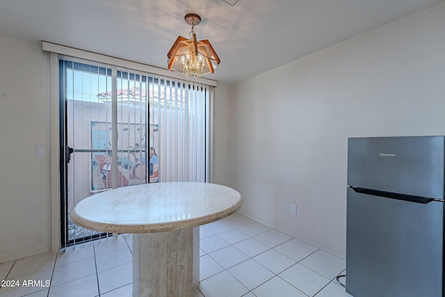 unfurnished dining area with light tile patterned flooring and an inviting chandelier