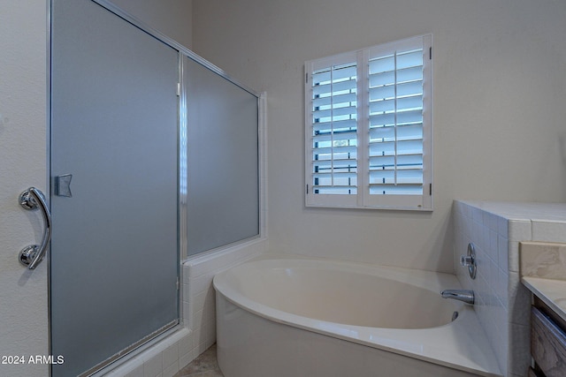 bathroom featuring vanity and independent shower and bath