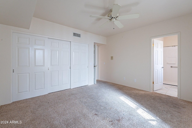 unfurnished bedroom featuring light carpet, a closet, and ceiling fan