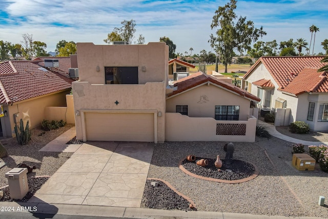 view of front of house featuring a garage and central AC