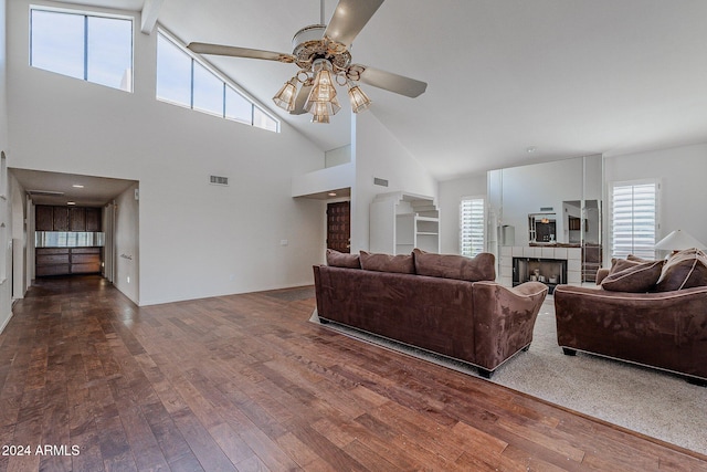 living room featuring ceiling fan, beamed ceiling, high vaulted ceiling, dark hardwood / wood-style floors, and a fireplace