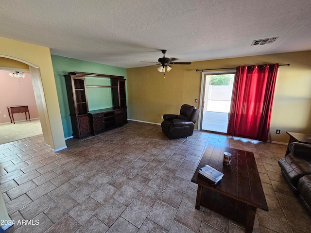 unfurnished living room with a textured ceiling and ceiling fan