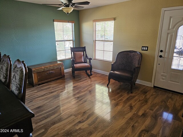 living area featuring dark hardwood / wood-style floors and ceiling fan