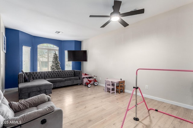 living room featuring light hardwood / wood-style flooring and ceiling fan