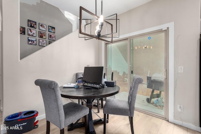 dining space featuring wood-type flooring and a chandelier