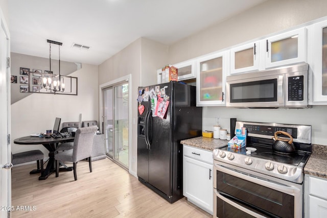 kitchen featuring hanging light fixtures, light hardwood / wood-style flooring, white cabinets, and appliances with stainless steel finishes