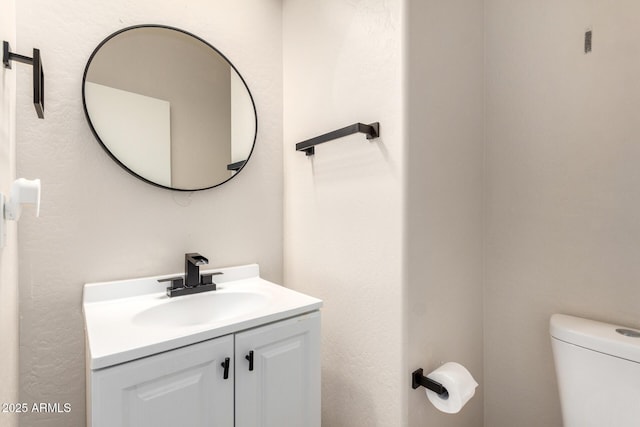 bathroom featuring vanity and toilet