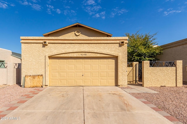 view of front of home with a garage, driveway, and stucco siding