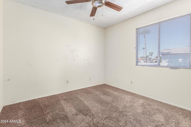 empty room featuring carpet, ceiling fan, and a textured ceiling