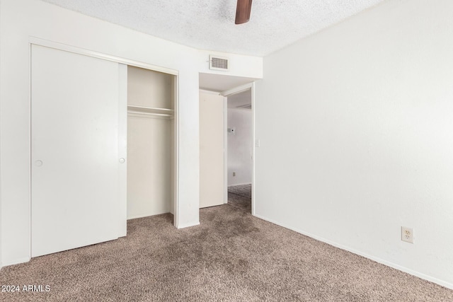 unfurnished bedroom featuring visible vents, a ceiling fan, carpet, a textured ceiling, and a closet