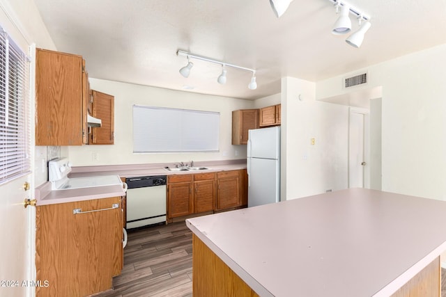 kitchen featuring brown cabinets, white appliances, visible vents, and light countertops