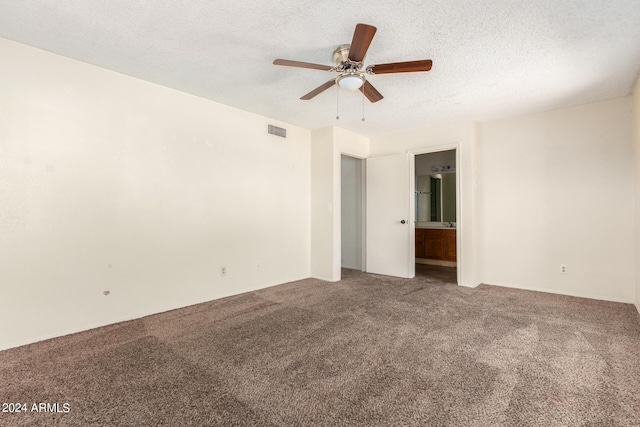 empty room featuring carpet, visible vents, ceiling fan, and a textured ceiling