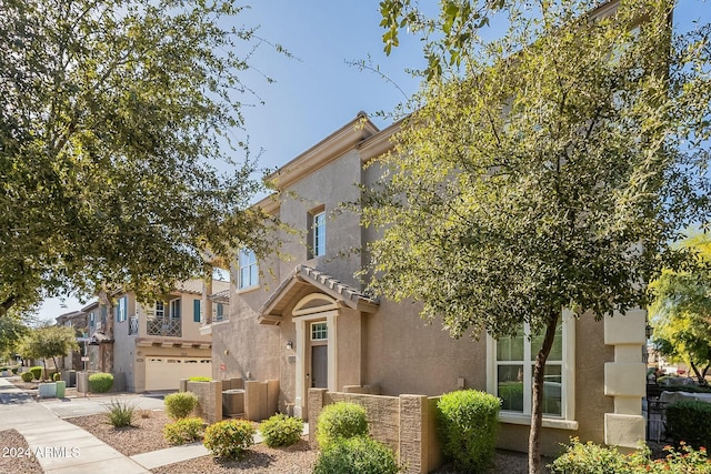 view of front of home with a garage and central air condition unit