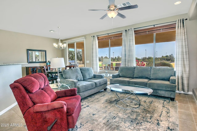 tiled living room with ceiling fan with notable chandelier