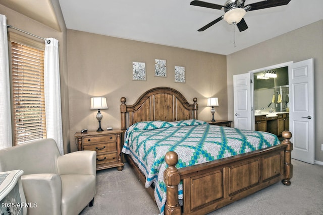 bedroom featuring ensuite bathroom, ceiling fan, and light carpet