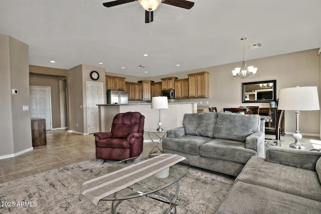 tiled living room with ceiling fan with notable chandelier