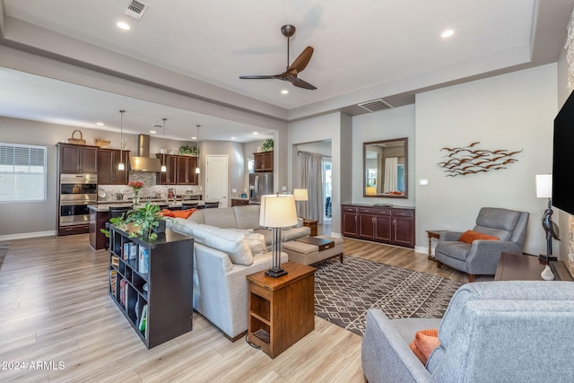 living room featuring light hardwood / wood-style flooring and ceiling fan