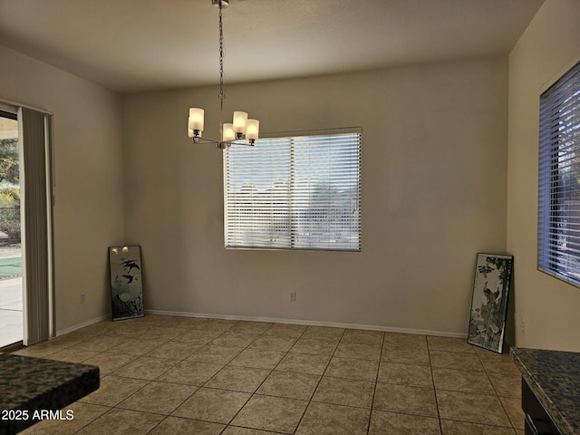 tiled dining room featuring a notable chandelier, plenty of natural light, and baseboards