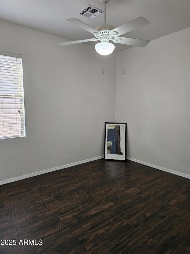 unfurnished room with visible vents, baseboards, dark wood finished floors, and a ceiling fan