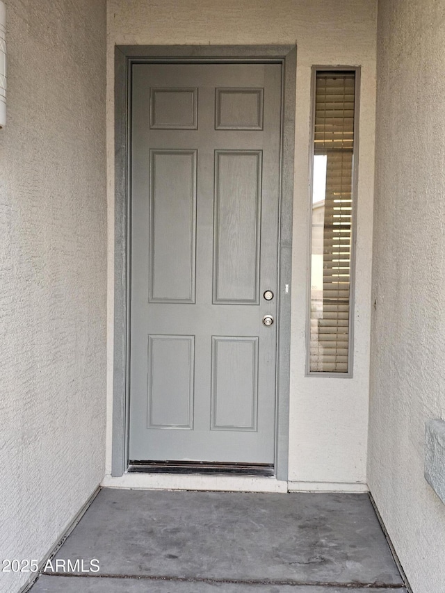 doorway to property with stucco siding