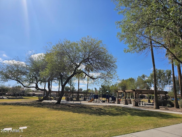 view of property's community with playground community and a lawn