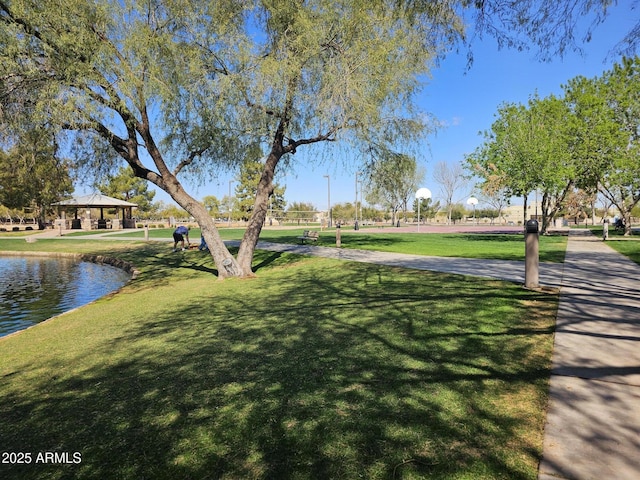 view of home's community with a gazebo, a yard, and a water view