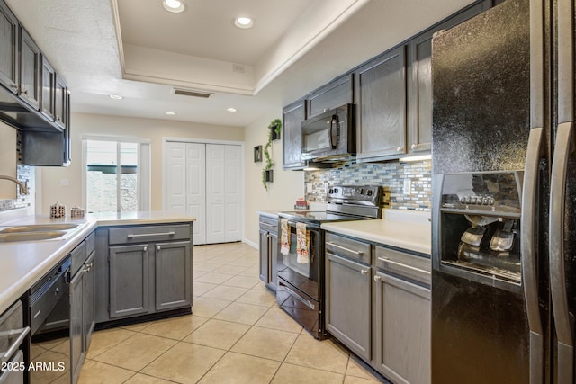 1342 W Emerald Ave Unit 286, Mesa, AZ 85202 - kitchen with black appliances, a sink, light tile patterned floors, light countertops, and a tray ceiling