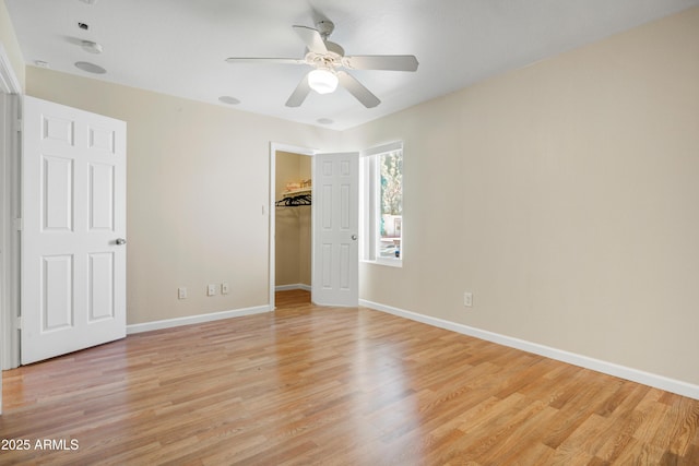 1342 W Emerald Ave Unit 286, Mesa, AZ 85202 - unfurnished bedroom featuring light wood-style floors, baseboards, a spacious closet, and a ceiling fan