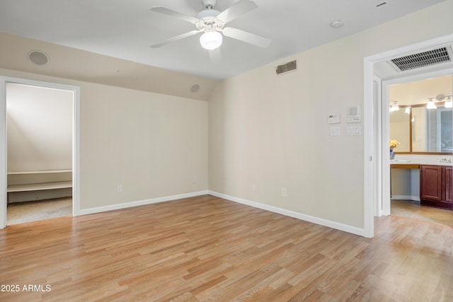 1342 W Emerald Ave Unit 286, Mesa, AZ 85202 - unfurnished bedroom with light wood-style flooring, baseboards, a ceiling fan, and a walk in closet
