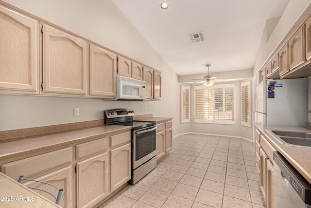 15011 W Verde Ln, Goodyear, AZ 85395 - kitchen with appliances with stainless steel finishes, vaulted ceiling, light tile patterned flooring, light countertops, and light brown cabinets