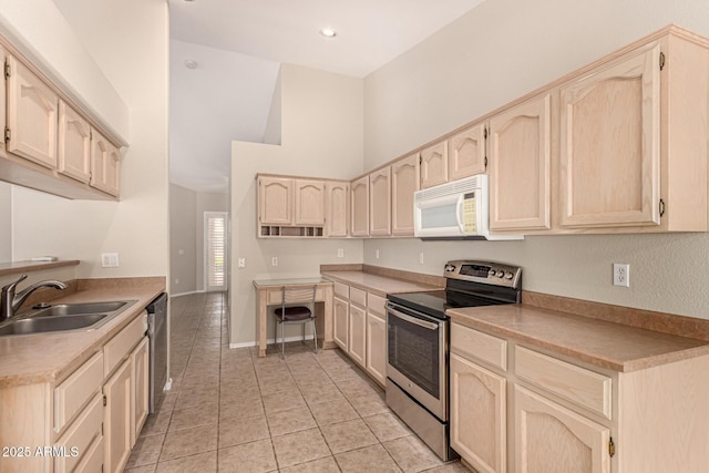 15011 W Verde Ln, Goodyear, AZ 85395 - kitchen featuring appliances with stainless steel finishes, light tile patterned floors, a high ceiling, light brown cabinetry, and light countertops