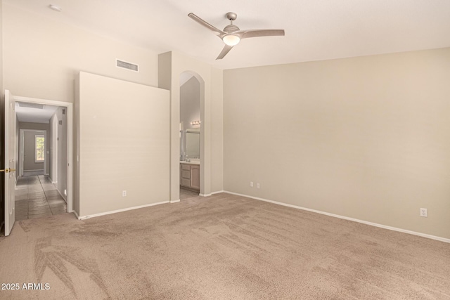 15011 W Verde Ln, Goodyear, AZ 85395 - unfurnished bedroom featuring carpet, arched walkways, a ceiling fan, and ensuite bath