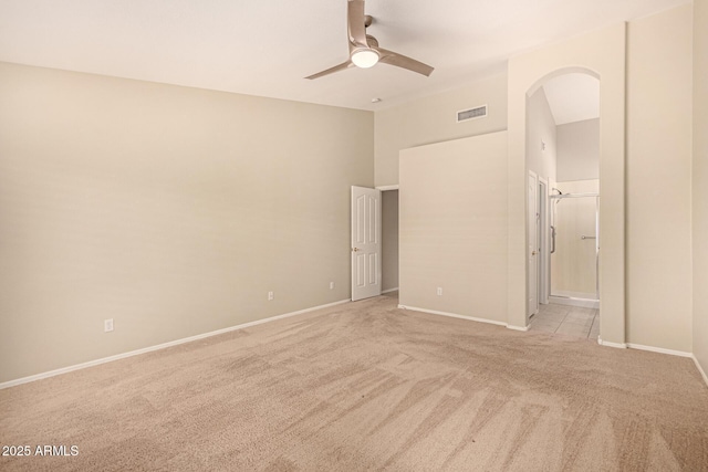 15011 W Verde Ln, Goodyear, AZ 85395 - unfurnished bedroom featuring light carpet, arched walkways, a ceiling fan, and ensuite bathroom