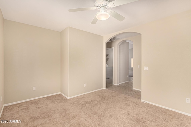 15011 W Verde Ln, Goodyear, AZ 85395 - spare room featuring washer / clothes dryer, arched walkways, light colored carpet, and a ceiling fan