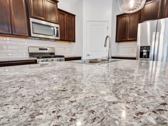 14160 W Georgia Dr, Surprise, AZ 85379 - kitchen featuring stainless steel appliances, tasteful backsplash, a sink, and light stone countertops