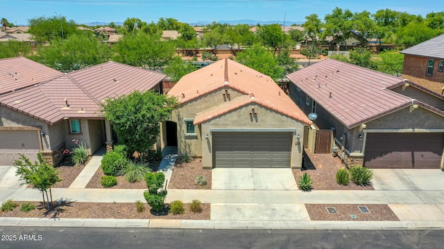 14160 W Georgia Dr, Surprise, AZ 85379 - view of front of home featuring concrete driveway, a tile roof, an attached garage, and stucco siding