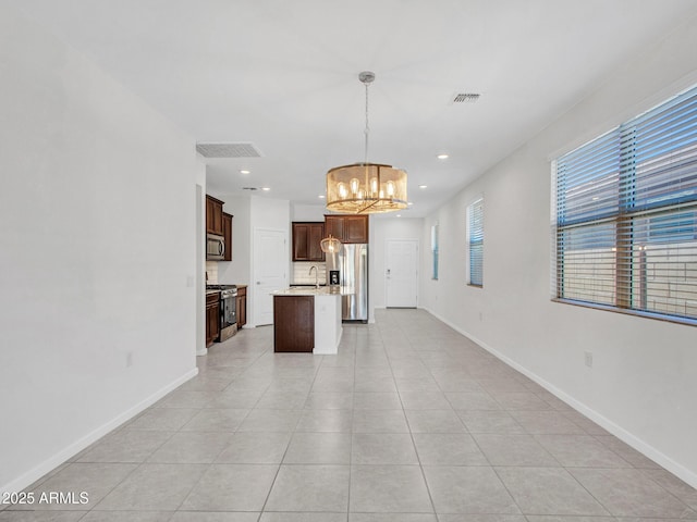 14160 W Georgia Dr, Surprise, AZ 85379 - kitchen featuring a chandelier, stainless steel appliances, a center island with sink, baseboards, and open floor plan