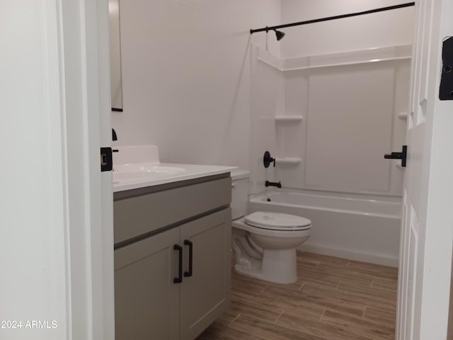 full bathroom featuring hardwood / wood-style floors, vanity, toilet, and shower / tub combination