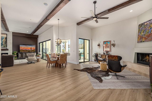 living room with recessed lighting, a fireplace, baseboards, light wood finished floors, and beamed ceiling